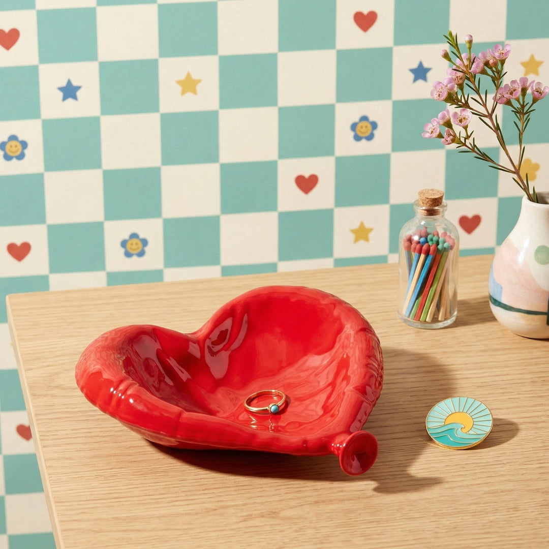 Red heart-shaped dish on a wooden surface with a checkered wall background