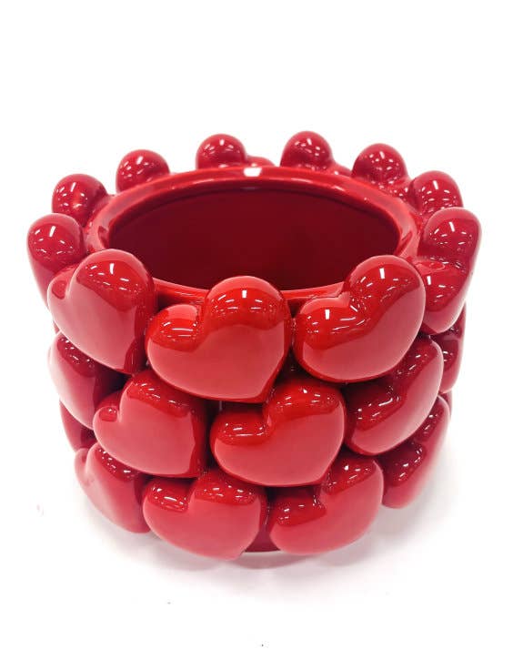 Red ceramic planter with heart designs on a white background