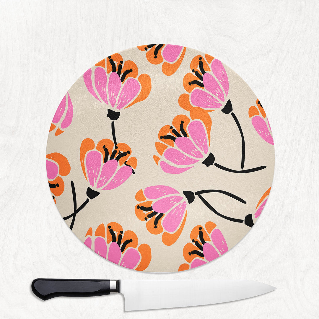 Round cutting board with floral pattern and a knife on a white background