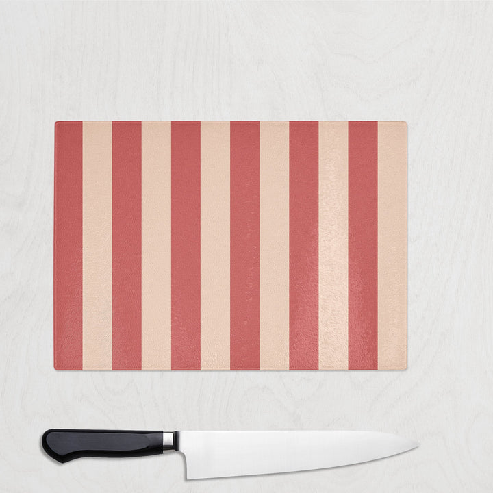 Striped cutting board with a knife on a light gray background