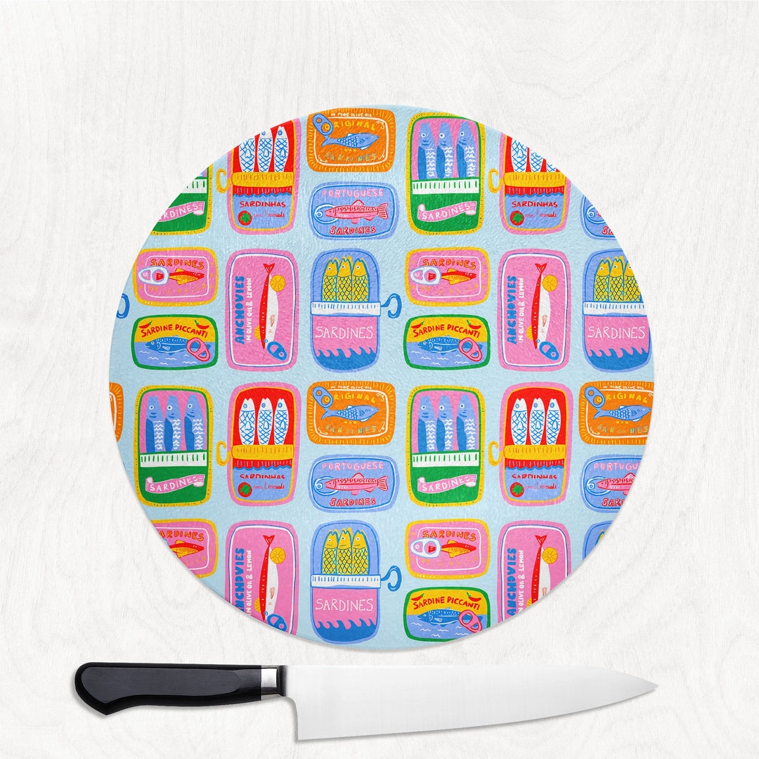 Round cutting board with colorful pattern and a knife on a white background
