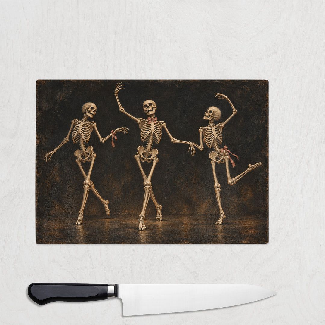 Skeleton Dance glass chopping board with three skeletons in bows dancing on black