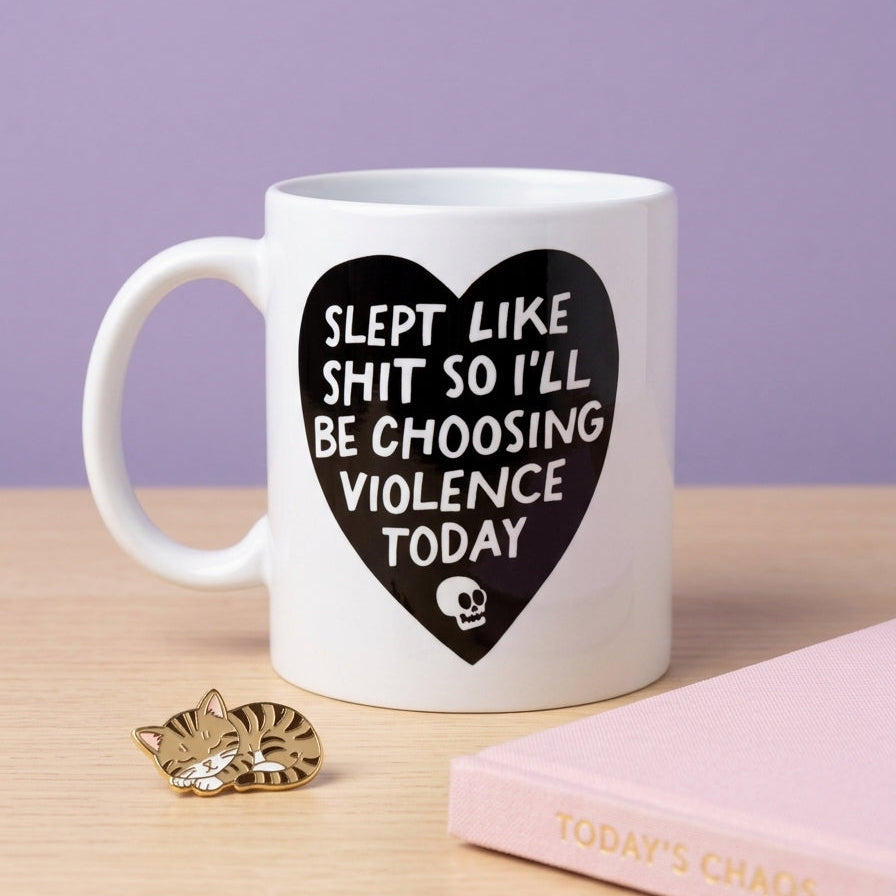 White mug with black heart-shaped text on a wooden surface with a purple background