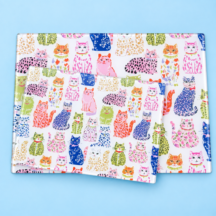 Two glass worktop savers large and small with a colourful cat pattern, set against a solid light blue backdrop.