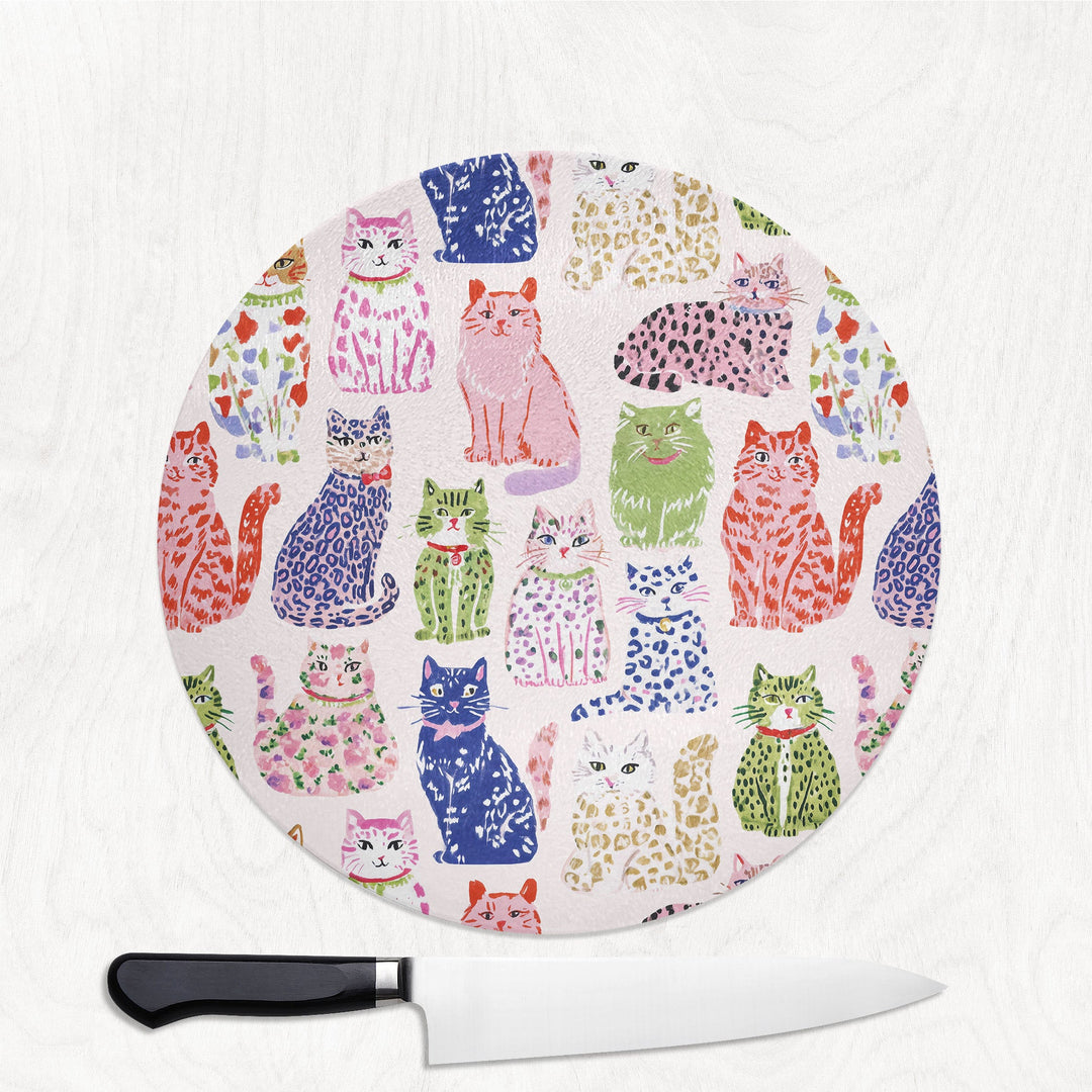 Spotty Cats round glass chopping board with playful spotty and leopard-print cats