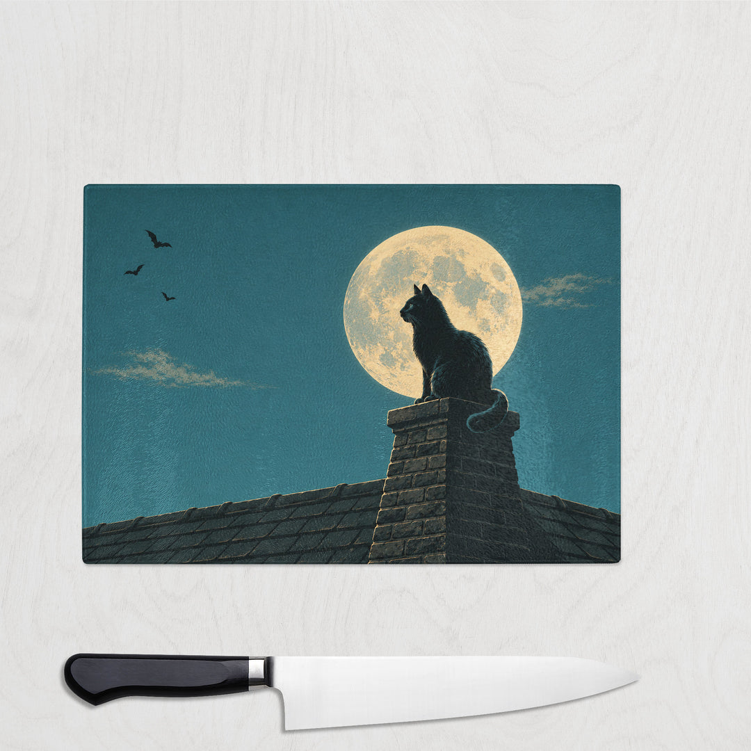 The Cat And The Moon glass chopping board with a black cat on a chimney pot watching bats under a huge moon