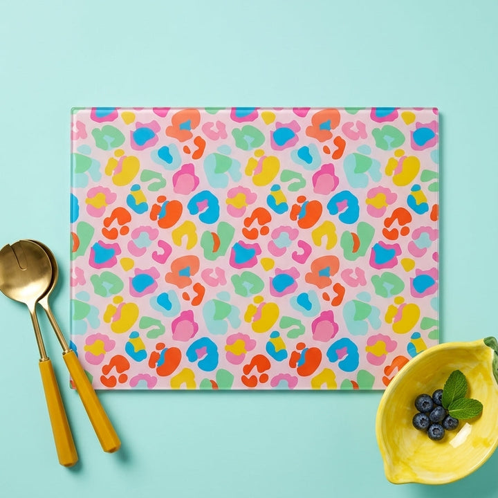 Colorful leopard print placemat with gold cutlery and a yellow bowl on a blue background
