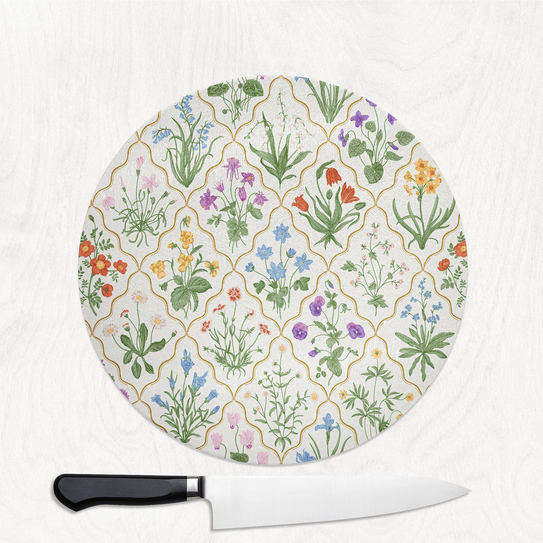 Round cutting board with floral pattern and a knife on a white background