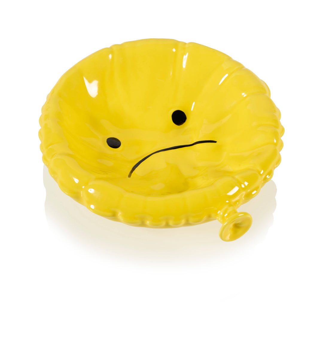 Yellow inflatable chair with a sad face on a white background
