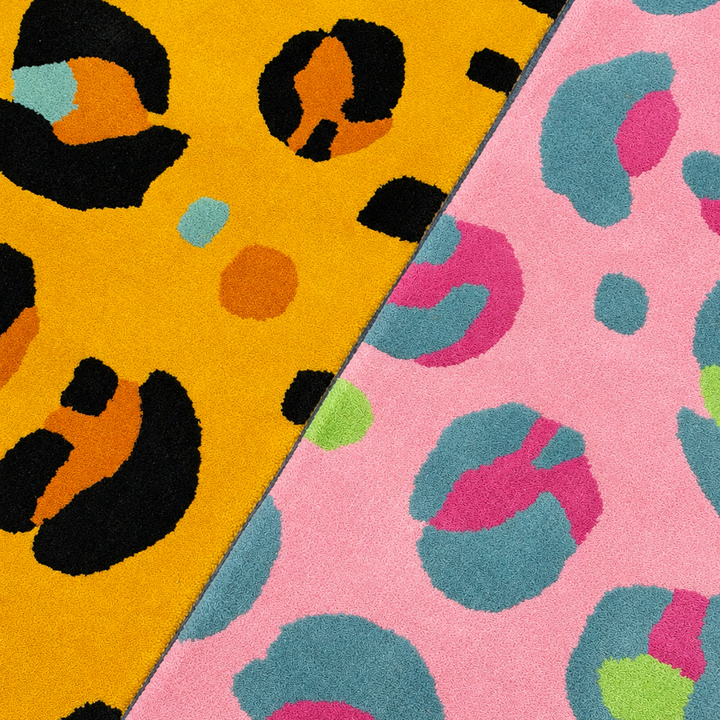 Two colorful leopard print rugs with animal print patterns, one electric yellow and orange and black, the other pink and blue.