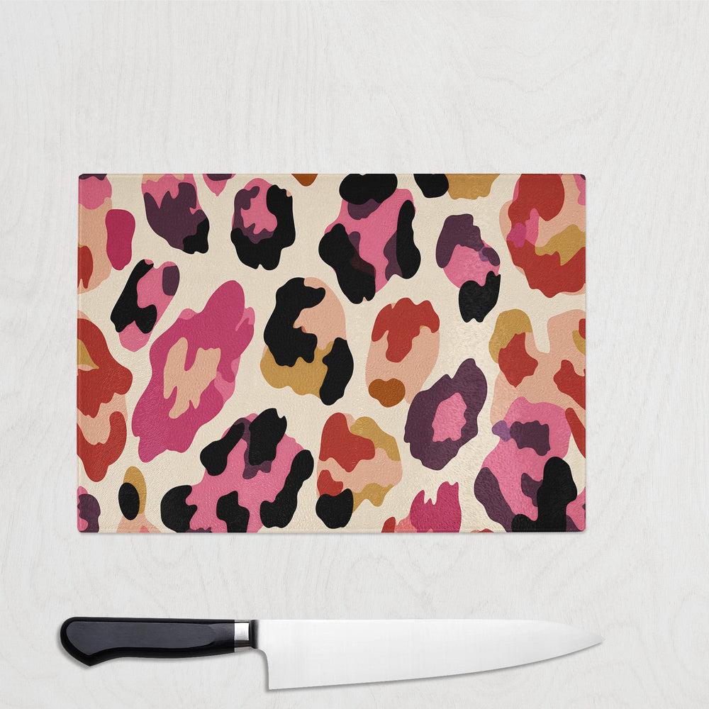 Colorful leopard print cutting board with a knife on a white background