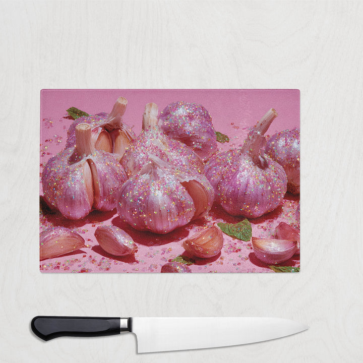 Sparkly pink garlic bulbs on a bright pink background – bold and fun garlic-themed glass chopping board.