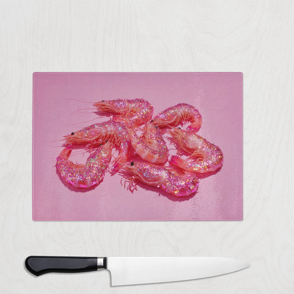 Pink glitter prawns on a bright pink background printed on a glass chopping board – bold, sparkly and fun seafood kitchen accessory.