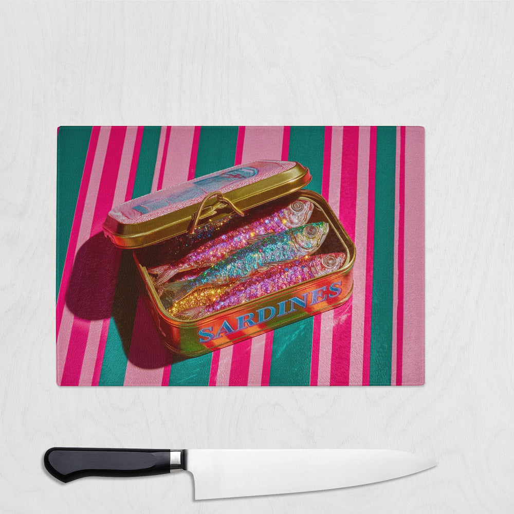 A glitter sardine tin filled with colourful sparkly fish on a bold pink and green striped background – printed on a glass chopping board.