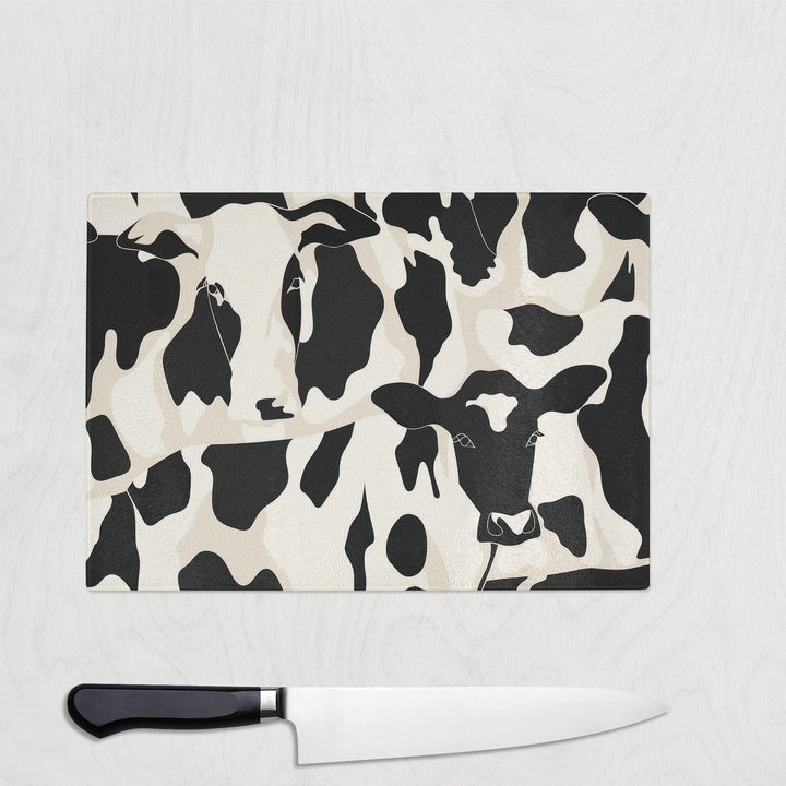 Black and white cow print glass chopping board with abstract hidden faces – Monochrome Moo design