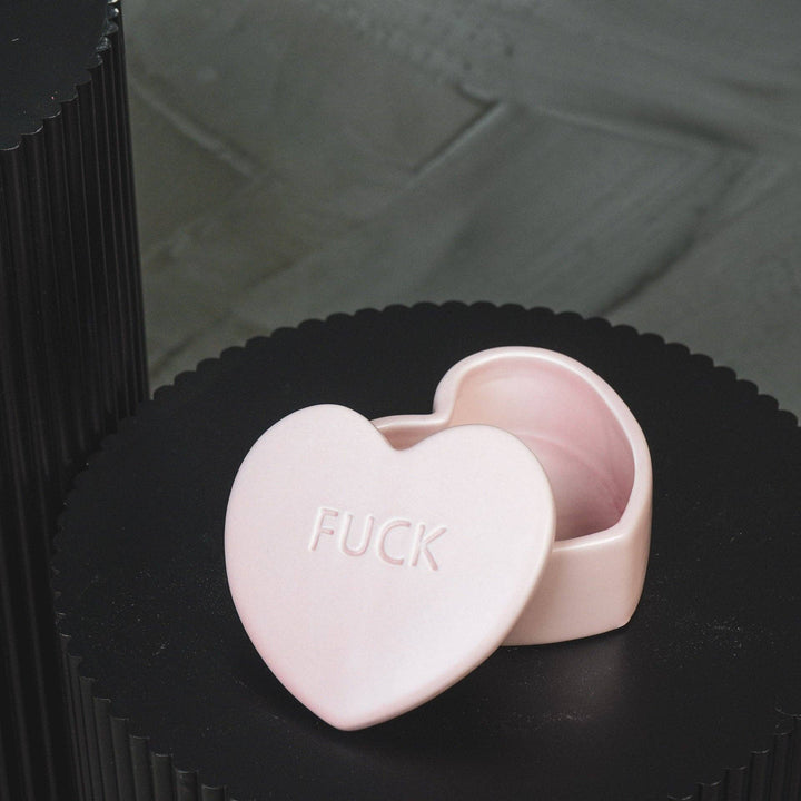 Heart-shaped pink box with 'FUCK' text on a black background
