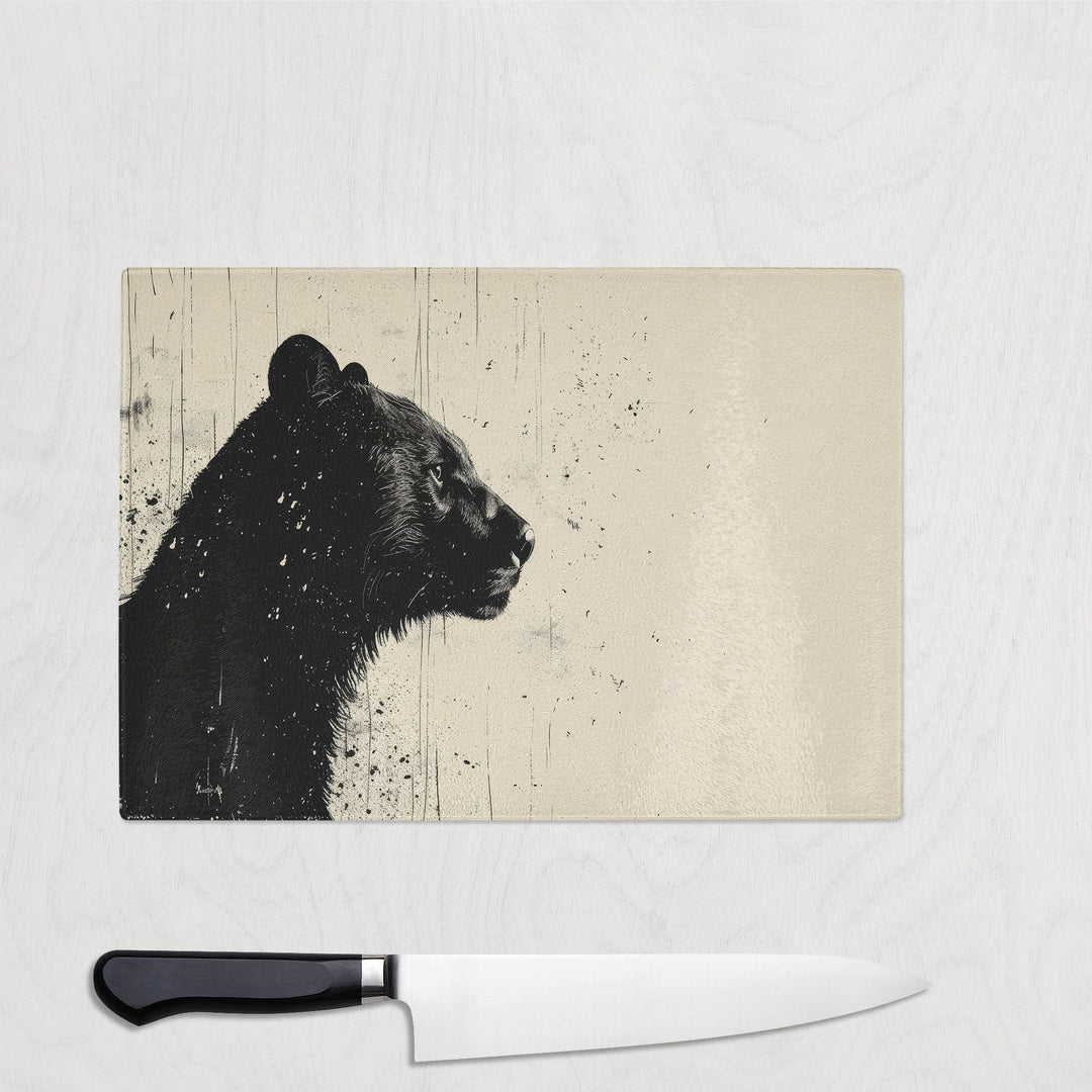 Glass chopping board featuring black bear profile with ink splatter effect on cream background – Shadow Bear design