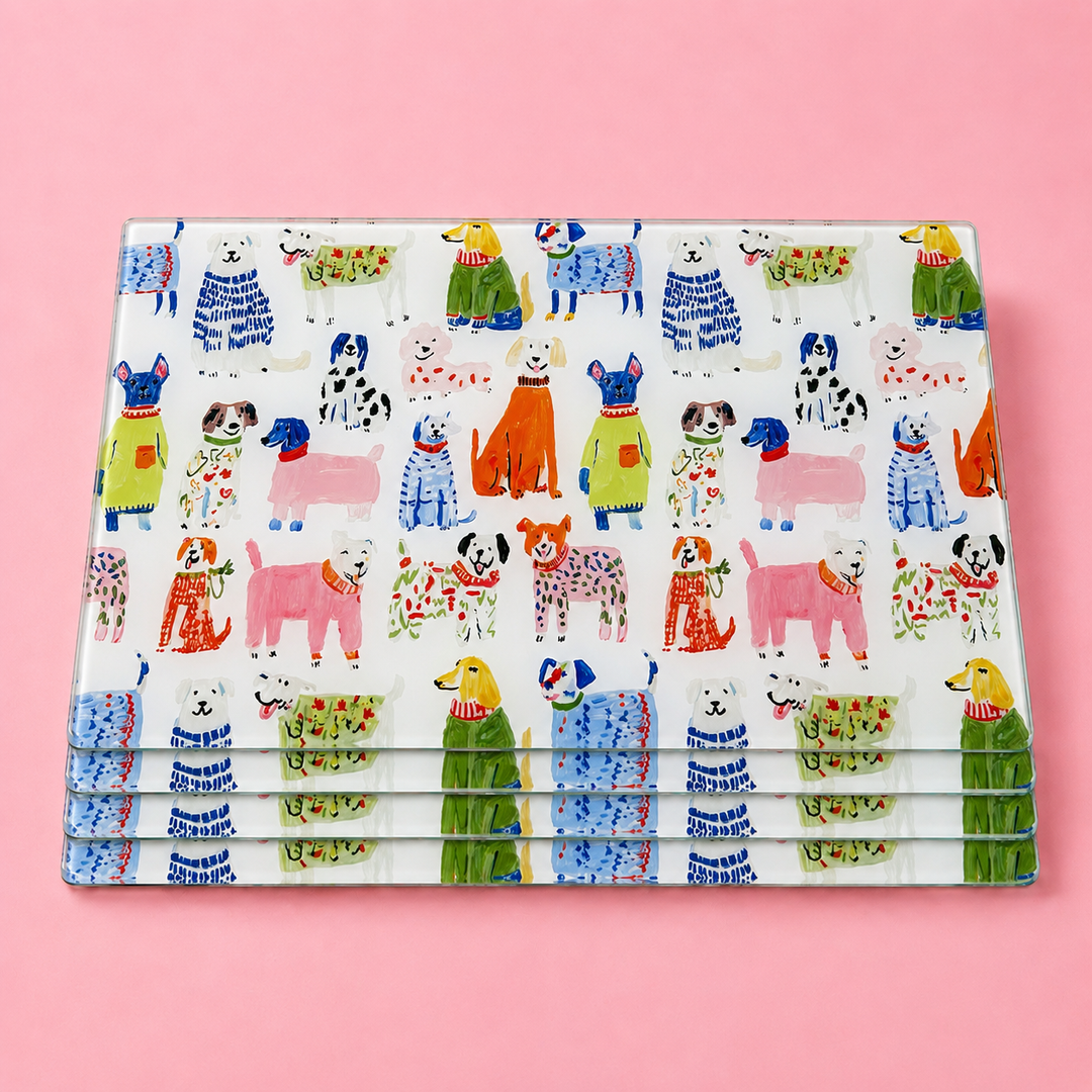 Stack of Yililo Colourful Dog glass placemats, printed with a pack of painterly, colourful dogs.