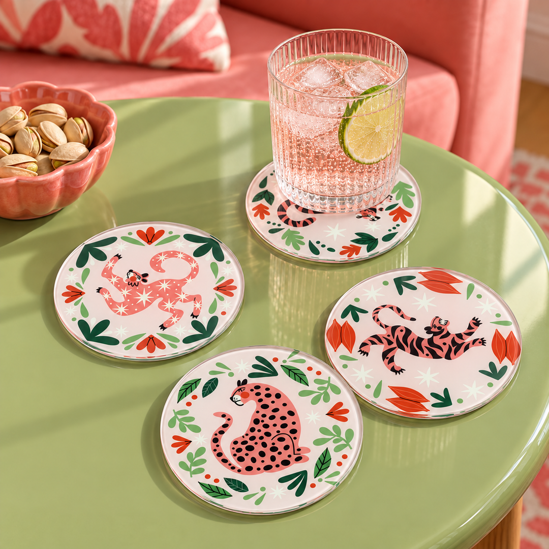 Lounging Pink Jungle Cat 4 piece glass coaster set, four round glass coasters each with a different lounging jungle cat on pink, matching the placemats
