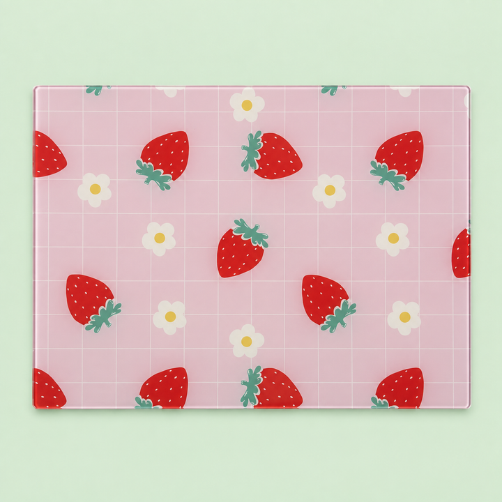 Strawberry Check glass chopping board with red strawberries and daisies on a pink grid, laid flat on a mint green background